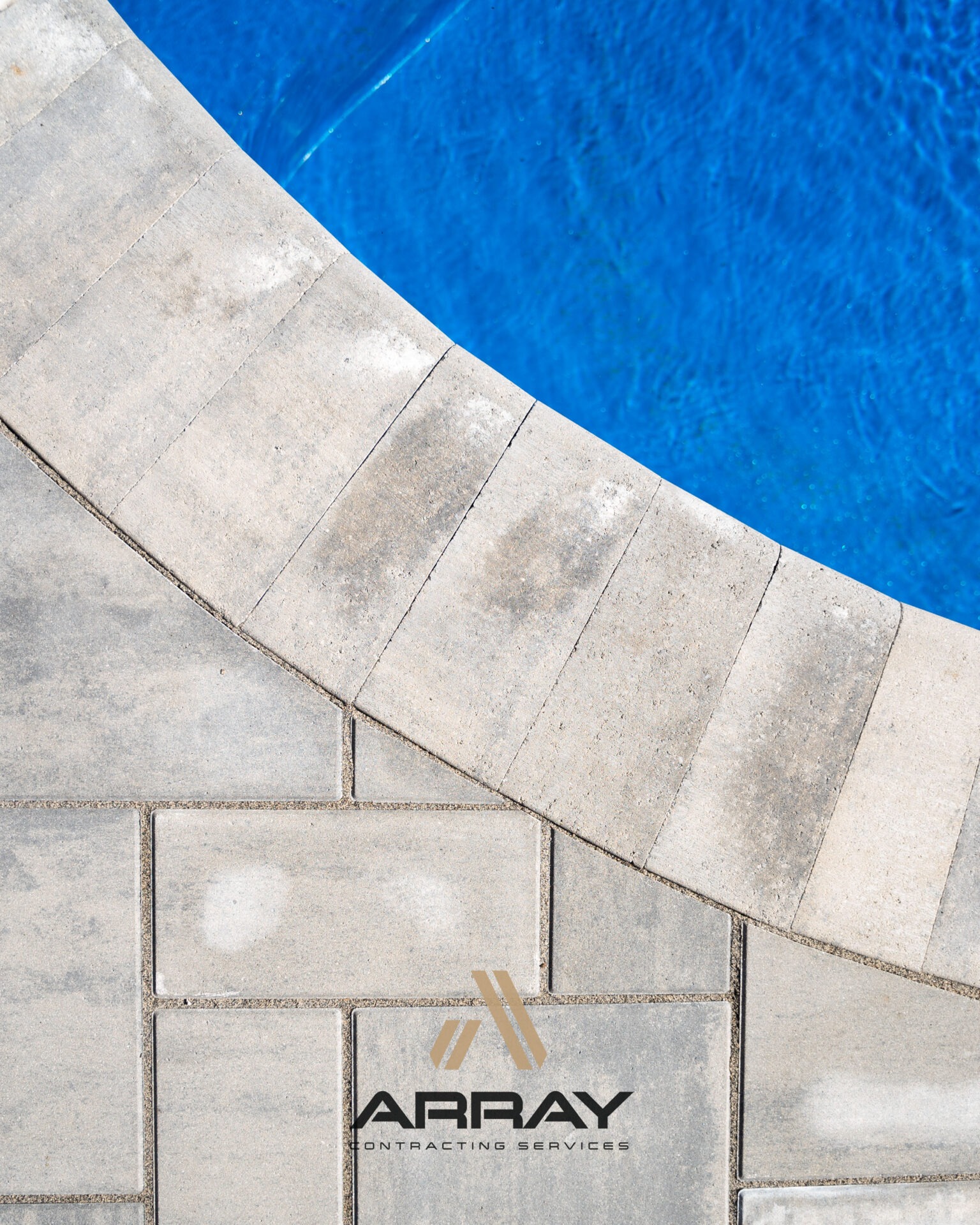 Stone poolside edge contrasts with vibrant blue water; company logo 